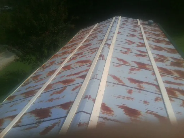 Rusted metal roof panels with new wood purlins before replacement — Storm Damage Roof Repair in Munson by Roofing Brothers