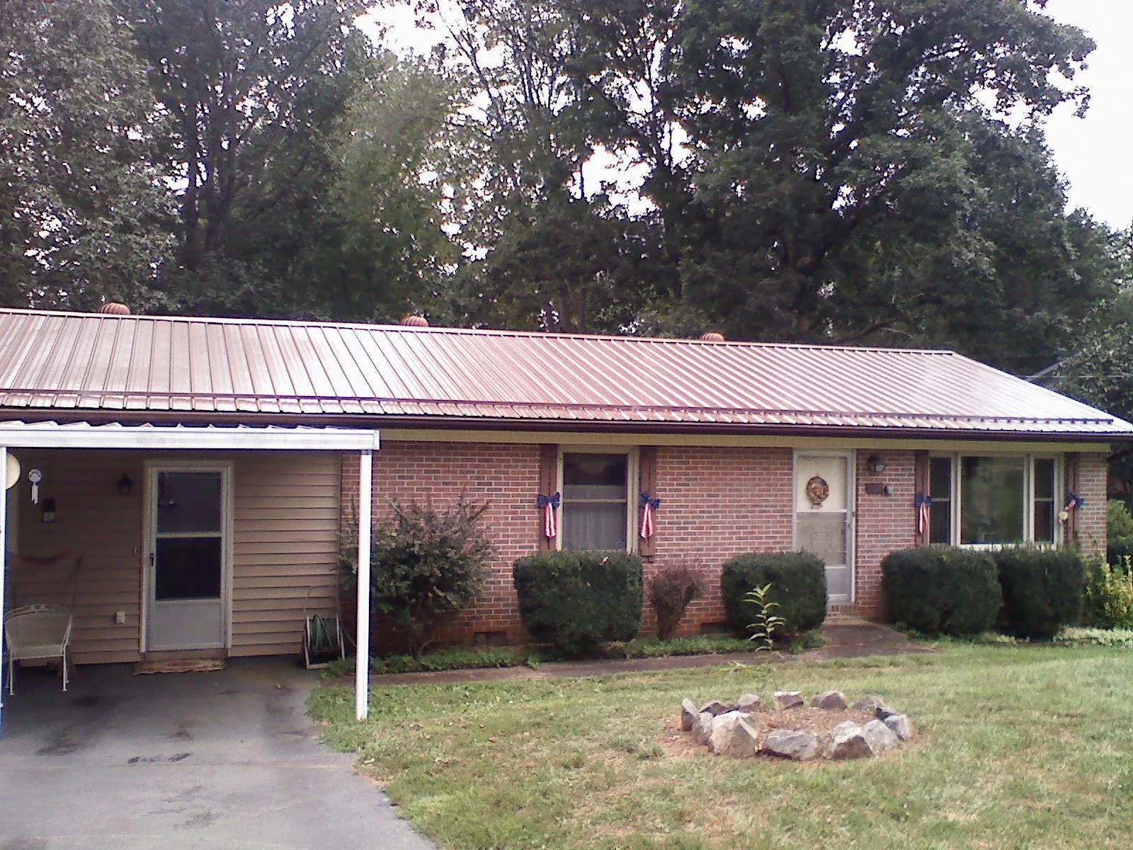 Bronze metal roof and carport on a brick ranch home — Roof Repair work by our crew in Munson